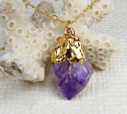 An amethyst crystal pendant accented with 18k gold on a gold-filled chain